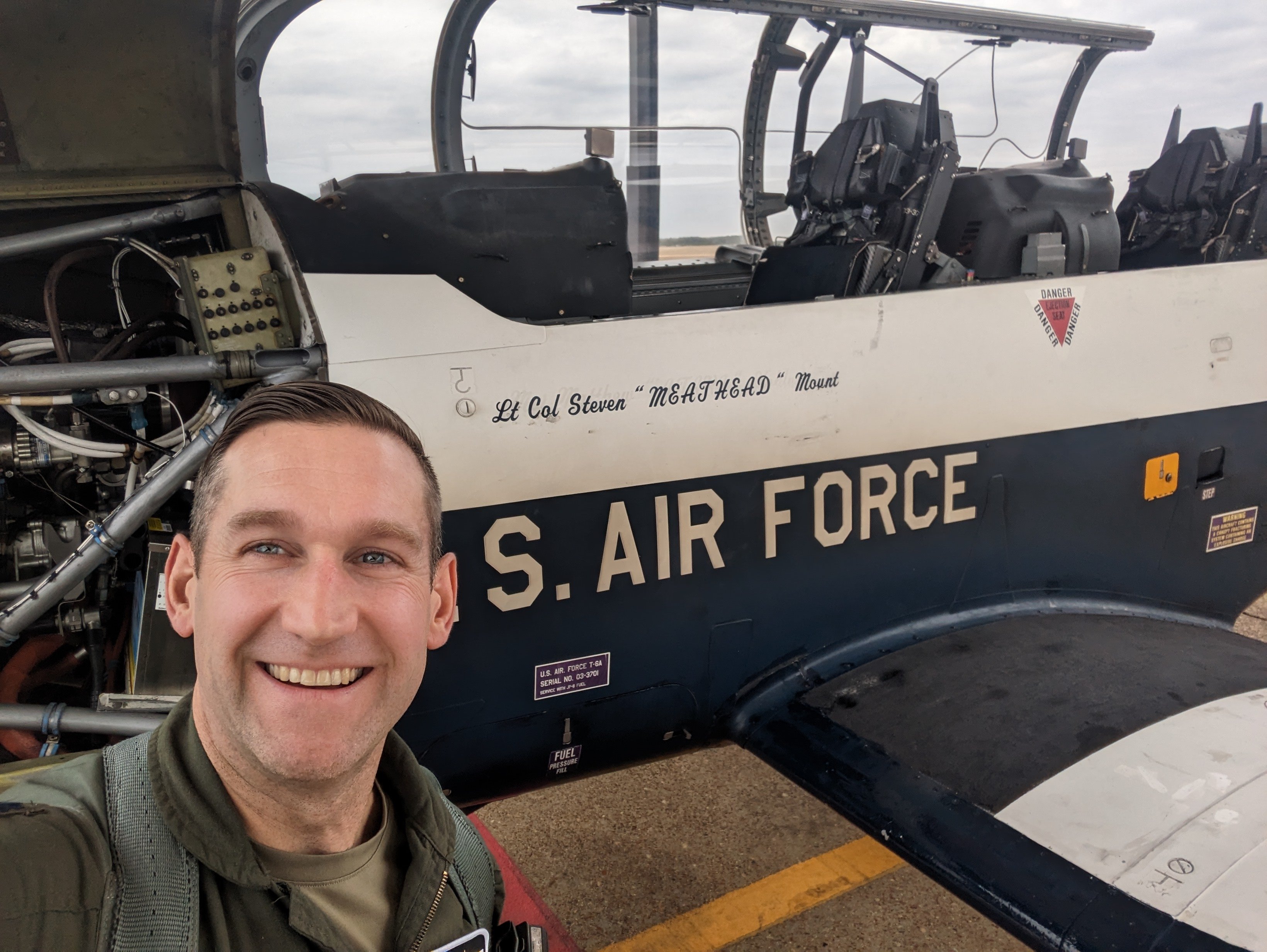 Lt. Col. Steven Mount ’08 standing in front of a T-6 Texan II emblazoned with his name and call sign
